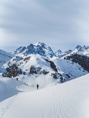 Person snowshoeing in snowy mountain landscape