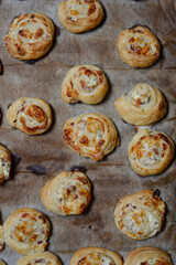 Close up of a tray with puff pastry rolls with cheese and ham