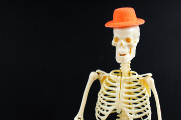 Skeleton Wearing Orange Hat on Black Background