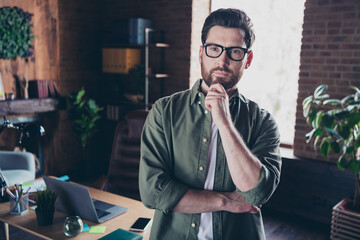 Photo of good mood thougthful specialist dressed shirt arms chin indoors workstation workshop
