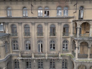Historic old 19th 20th century ruined derelict abandoned hotel house building facade scene, with arcade decorated terrace and greek style columns