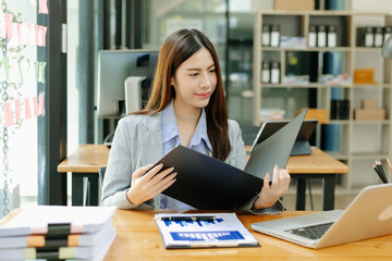 Portrait of female office businesswoman startup daydreaming about her work, startup and working with laptop on office desk in office room