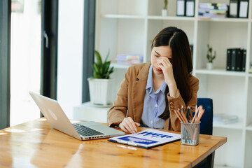 Obraz premium Woman who is tired and overthinking from working with tablet and laptop at modern office...