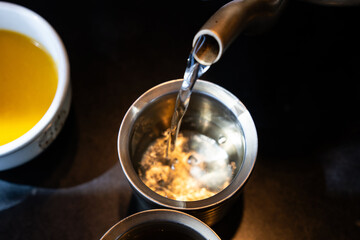 pouring water from kettle to cup