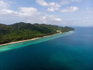 Fototapeta premium A stunning aerial view of a coastal landscape featuring lush greenery and clear blue waters.