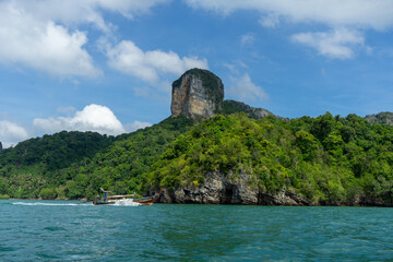 A serene view of a lush, rocky island surrounded by turquoise waters.