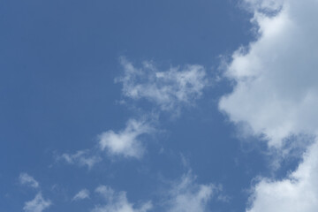 A clear blue sky with wispy clouds scattered across.