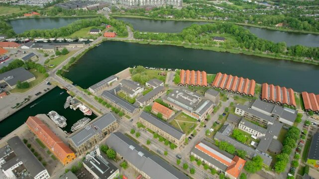 Aerial view of copenhill power plant with wind turbines and greenery along the canal, copenhagen, denmark.