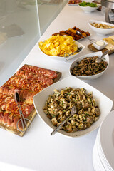 A beautifully arranged hotel buffet featuring savory sliced paio, cured ham, sautéed mushrooms, pork ear with coriander, and crispy fries, showcasing a feast of flavors.