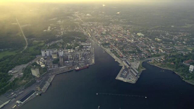 Aerial view of the industrial harbour with boats and a pier at sunset, Karlshamn Citadel, Sweden.