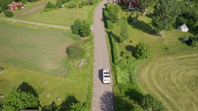 Aerial view of tranquil siljan lake surrounded by rustic houses and lush pine forest, mora, sweden.