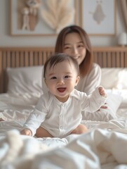 Fototapeta premium an Asian baby boy playing with his mum on a bed. with a light smile.