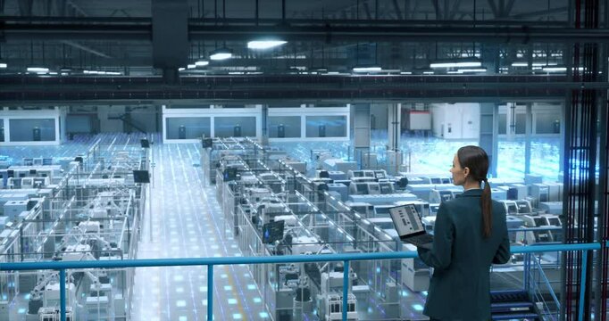 Factory Digitalization Visual Transformation: Female Engineer Uses Laptop to Activate Construction of Autonomous Robot Arm Industrial Facility. Industry Four Machinery Manufacturing of Products