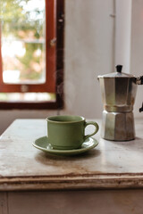 A cup of hot coffee from the coffee maker on a wooden table. Making strong coffee in a moka pot