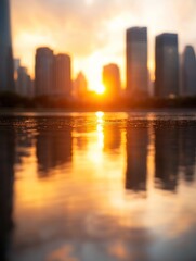 Fototapeta premium A serene sunset casts an orange glow over urban skyscrapers, reflected in calm water, creating a picturesque cityscape scene.