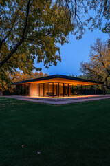 Fototapeta premium Modern architectural design of a stunning house surrounded by trees during twilight