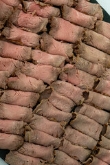 Delicate slices of roast beef elegantly displayed on a hotel buffet, inviting guests to indulge in a delicious culinary experience.
