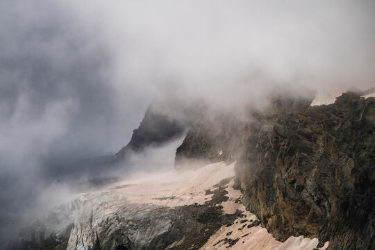 View of majestic Fee Glacier and rugged peaks shrouded in fog, Saas Fee, Switzerland.