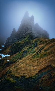 View of Puy de Sancy mountain peak surrounded by mist and grass, Mont Dore, France.