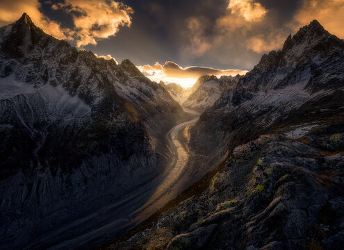 View of la mer de glace with majestic mountains and a dramatic sky at sunset, Chamonix, France.
