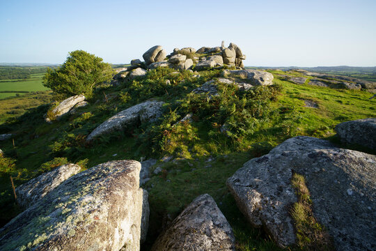 View of helman tor with rugged rocks and greenery under a blue sky, Bodmin, England.
