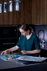 Young woman is making cookies in her kitchen