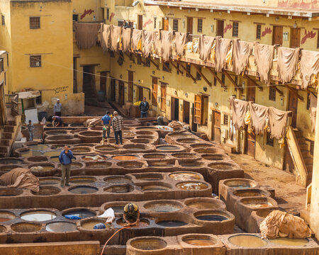 Fès, Morocco - 21 November 2023: View of traditional tannery with vibrant dye vats and workers, Fes, Morocco.