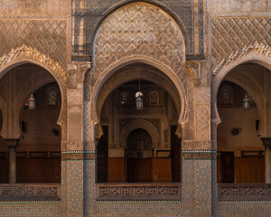 View of ornate arches and intricate mosaics of Madrasa Bou Inania, Fes, Morocco.
