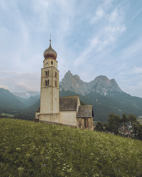 View of St. Valentin Church surrounded by serene mountains and picturesque countryside, San Valentino, Italy.