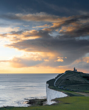View of seven sisters cliffs with belle tout lighthouse at sunset, eastbourne, united kingdom.