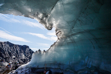 View of majestic Katla Ice Cave with beautiful ice formations and icy mountains under a blue sky, Vik, Iceland.