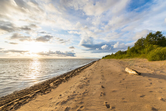 View of tranquil beach with sand and ocean under a beautiful sunset, Paernu, Estonia.