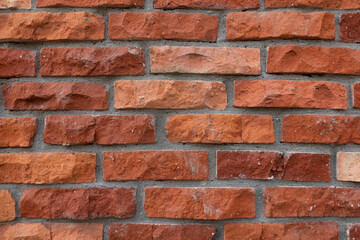 Fragment of a red brick wall with picturesquely chipped edges. Rustic. Background. Texture.