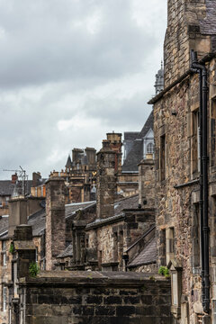 View of historic stone buildings and chimneys under a cloudy sky, Edinburgh, United Kingdom.