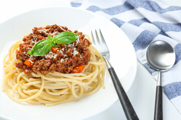 Delicious pasta bolognese and cutlery on white table, closeup