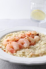 Delicious risotto with shrimps and cheese on table, closeup