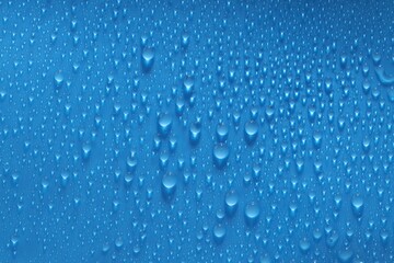 Water drops on blue background, top view