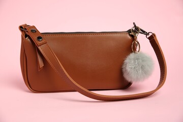 Brown bag with grey faux fur keychain on pink background