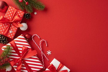 Elegant top view Christmas presents with red ribbons and various festive decorations arranged on a vibrant red background, conveying warmth and holiday cheer
