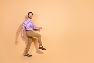 Full body photo of attractive young man walk step stairs dressed stylish striped formalwear...