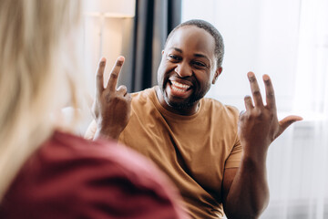 Happy young couple communicating through sign language at home