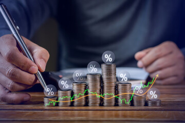 Businessman putting down money, pointing with pen and showing candlestick symbol for investing,...