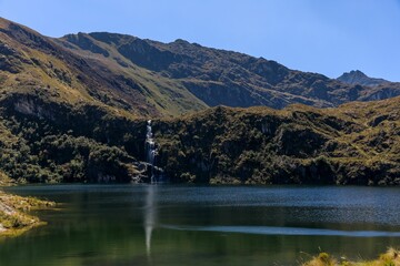 Mountain landscape with waterfall and lake.