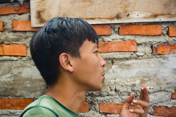 An adult male is smoking a cigarette