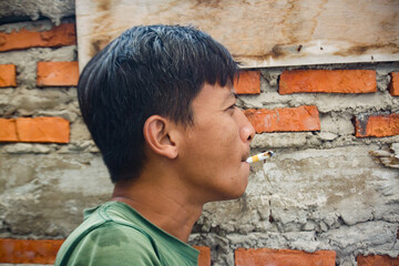 Fototapeta premium An adult male is smoking a cigarette