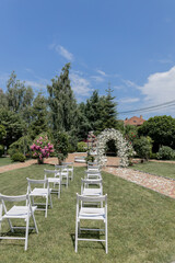 a beautiful arch for a wedding ceremony in a park with chairs