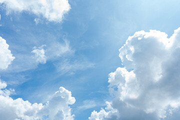 Beautiful fluffy white clouds drift across a clear blue sky, casting soft shadows on the Earth