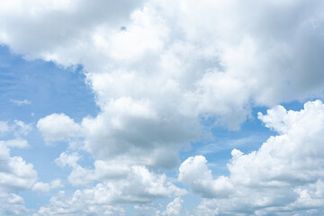 Fluffy white clouds drift across a vibrant blue sky, creating a breathtaking natural spectacle