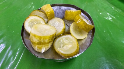 Marinated pickled cucumber slices on tin plate. Tasty pickled cucumbers on tin bowl 