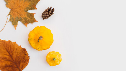 Autumn holiday frame composition with pattern made of leaf, punpkins, dried orange, pine cone on...
